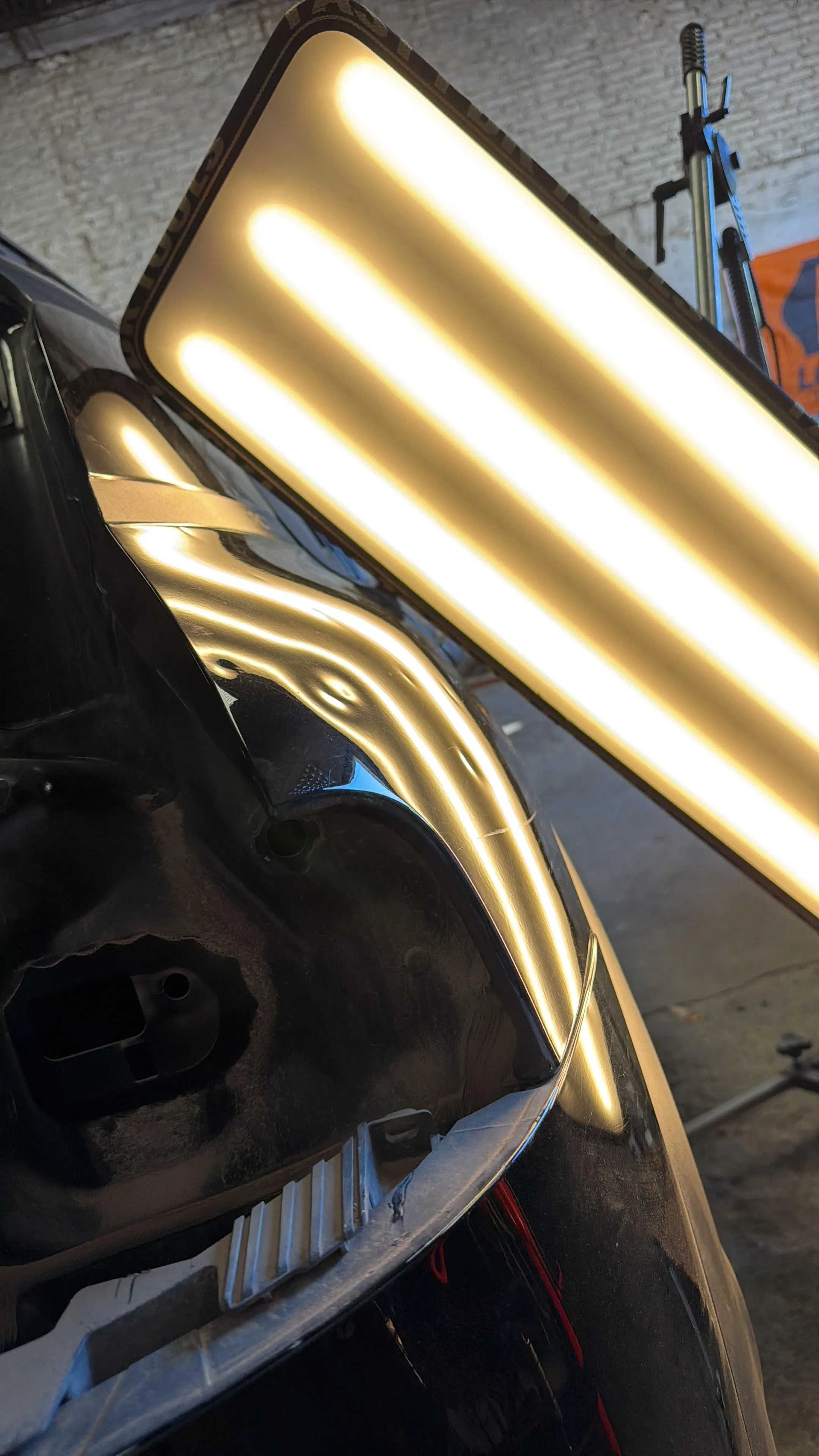 Technician repairing a dent on a fender